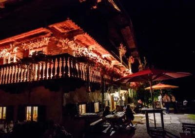 Stimmungsvolle Hochzeitsfeier im Hasenoehrlhof Geitau bei Bayrischzell, beleuchteter Hof bei Nacht.