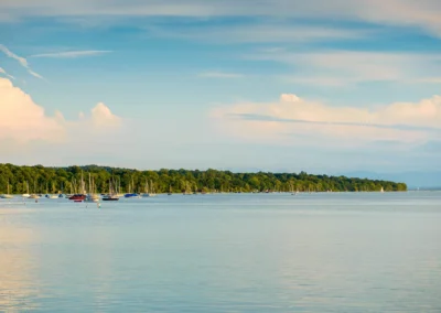 Abendhochzeit am Seehaus Schreyegg am Ammersee, Boote und Wasser unter blauem Himmel.