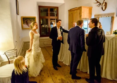 Brautpaar unterhalt sich mit Gaesten bei Hochzeitsfeier im Schloss Pertenstein, Chiemgau. Romantische Trauung Atmosphaere.