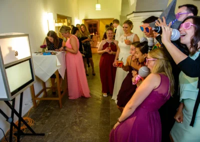 Gäste bei Hochzeit auf Schloss Hohenkammer mit Fotobox und lustigen Accessoires. Perfekt für Hochzeitsreportage.