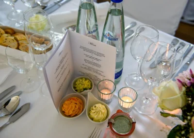 Hochzeitstafel im Hotel Aiterbach am Chiemsee, festlich gedeckt mit Speisekarte und Kerzen.