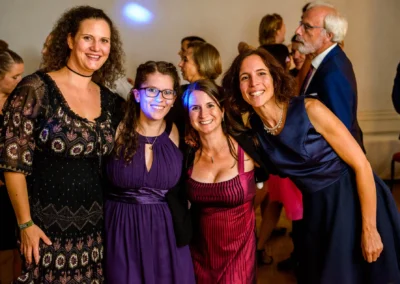 Vier Frauen posieren lachend bei einer Hochzeitsfeier im Schloss Pertenstein. Gesellige Stimmung bei der Hochzeit.