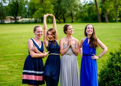 Vier lachende Frauen auf Hochzeit im Hotel Aiterbach am Chiemsee, festliche Atmosphaere, gruenes Panorama.