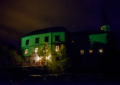 Nachtszene von Schloss Pertenstein, beleuchtet fuer eine Hochzeitsfeier im Chiemgau, romantische Atmosphaere.