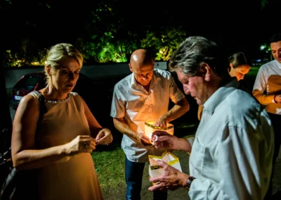 Gaste auf einer abendlichen Hochzeitsfeier in Inning am Ammersee, beleuchtet von Kerzenlicht im Freien.