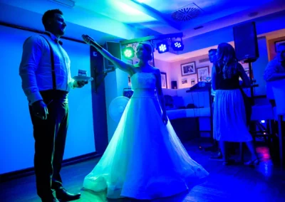 Abendliche Hochzeitsfeier in Muenchen, Braut und Bräutigam beim Feiern unter blauer Beleuchtung.