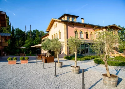 Hochzeitsreportage bei La Villa, Pocking: elegante Hochzeitslocation mit Terrasse und Baeumen im Sonnenschein.