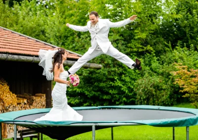 Brautpaar-Portrait auf Trampolin bei Trauung in Königsdorf, freudige Momente und Lustiges in Hochzeitsreportage.