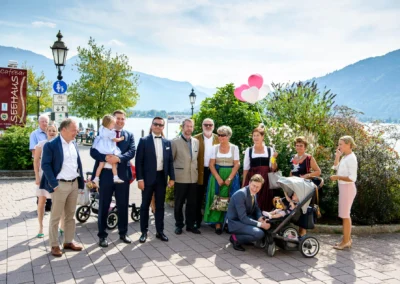 Hochzeitsgesellschaft am Tegernsee mit Ballons und Kinderwagen bei einer Hochzeitsreportage in Bayern.