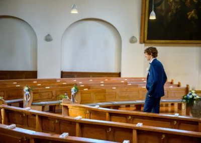 Bräutigam in leerer Kirche bei Hochzeit in München, Hochzeitsreportage, elegantes Ambiente, Trauung im Fokus.