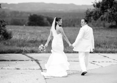 Brautpaar-Portrait in Königsdorf, Hand in Hand, lächelnd, Hochzeitsshooting auf einem Weg mit natürlicher Kulisse.