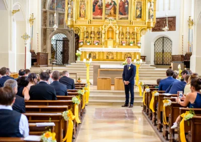 Kirchliche Trauung in Bad Toelz, festlich geschmueckte Kirche mit Gaesten, Teil einer Hochzeitsreportage.