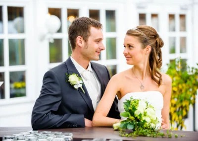 Brautpaar bei Hochzeit in Pullach, Brautstrauss und Anzug, lichtdurchfluteter Hintergrund, Hochzeitsfoto.
