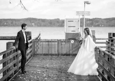 Brautpaarfoto am Steg in Bernried, Braut und Braeutigam beim Fotoshooting waehrend ihrer Hochzeitsreportage.