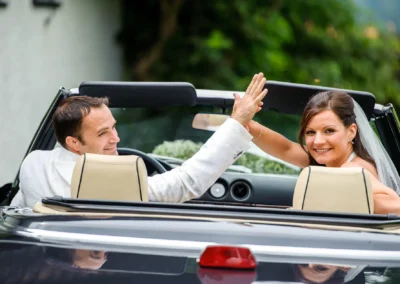 Brautpaar beim Hochzeitsfotoshooting im Cabrio, Königsdorf, freudiger Moment im Auto, Hochzeitsreportage.