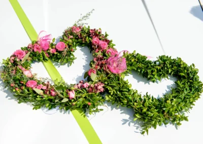 Herzkranz aus gruenem Laub und rosa Blumen, aufgenommen bei einer Hochzeit im Rathaus Tegernsee.