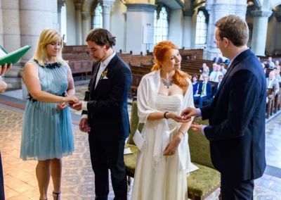 Kirchliche Trauung in der Lukaskirche: Brautpaar tauscht Ringe in festlichem Ambiente in Muenchen-Lehel.