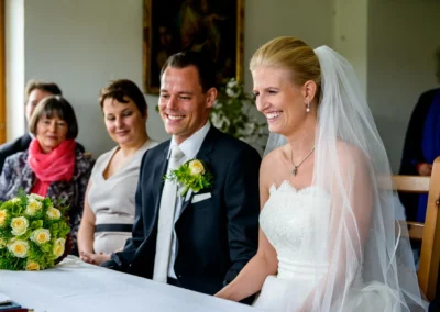 Brautpaar bei standesamtlicher Trauung in Dietramszell, Hochzeit in Oberbayern, festlicher Moment am Tisch.