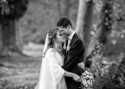 Brautpaarfotos in Bernried, eng umarmt mit Blumenstrauss. Hochzeitsfotografie am Starnberger See. Romantische Szene.