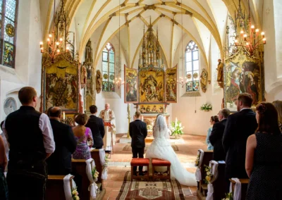 Kirchliche Trauung in Muenchen, Brautpaar vor Altar in historischer Kirche, Hochzeitsreportage in Obermenzing.