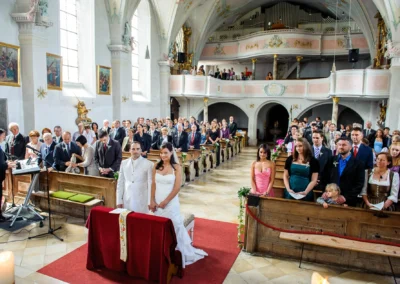 Kirchliche Trauung in Königsdorf: Brautpaar und Gäste in historischer Kirche, Hochzeit Reportage südlich von München.