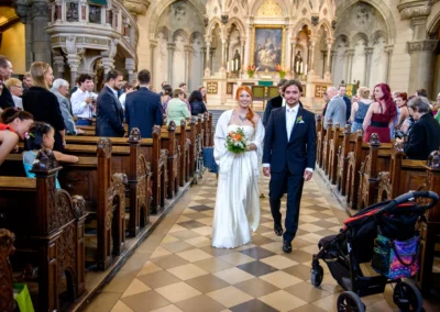 Brautpaar verlaesst Kirche nach Trauung in Lukaskirche, Muenchen-Lehel, umgeben von Gaesten. Hochzeitsfotografie.