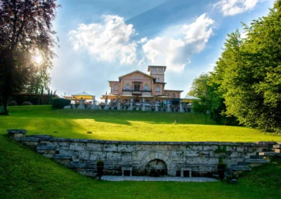 Ein elegantes Herrenhaus bei einer Hochzeit in La Villa, umgeben von gruener Landschaft und strahlendem Himmel.