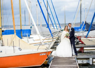 Brautpaarfotos am Steg mit Segelbooten bei einer Hochzeit in Bernried am Starnberger See, Hochzeitsfotograf Bayern.
