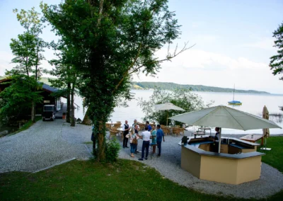 Lauschige Hochzeitslocation am Starnberger See mit Pavillon und Gästen bei der Feier im Freien in Bayern.