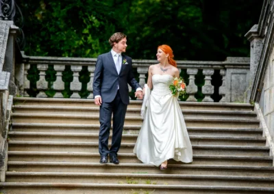 Brautpaar bei Hochzeitsportraits auf Treppe in Muenchen-Bogenhausen. Hochzeitsfotografie, elegante Stufen.