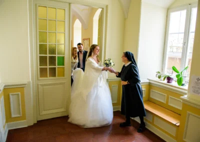 Braut reicht Schwester die Hand in Kirche in Bernried waehrend einer Hochzeitsreportage, Hochzeitsfotograf Bayern.