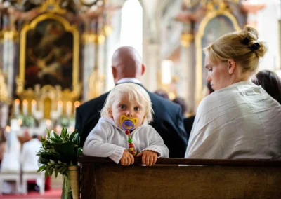 Kind mit Schnuller während kirchlicher Trauung in Königsdorf. Hochzeitsreportage zeigt Feier von Hochzeiten südlich von München.