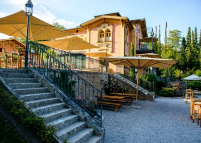 Hochzeitslocation La Villa in Bayern mit Treppe, Blumen und Sonnenschirmen, ideal fuer Hochzeitsreportage.
