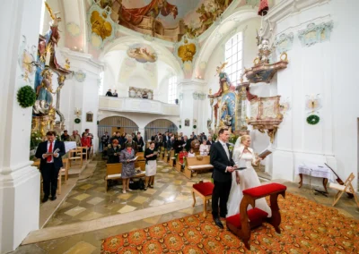 Kirchliche Trauung in St. Leonhard, südlich von München, festgehalten in einer Hochzeitsreportage in Oberbayern.