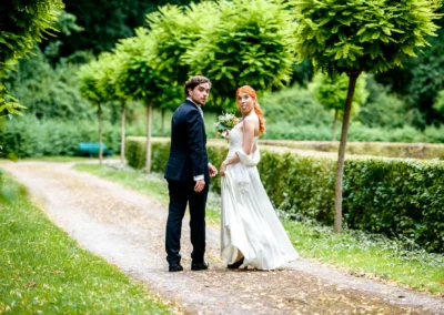 Brautpaar bei Hochzeitsportraits im Park in Muenchen-Bogenhausen, umgeben von gruener Natur und Baeumen.