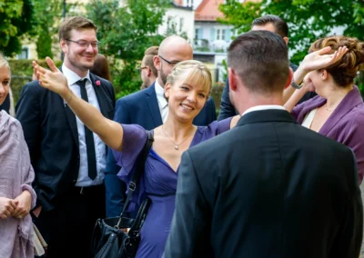 Lächelnde Frau begruesst bei einer Hochzeit in Perlach, München. Hochzeitsfoto zeigt freudige Stimmung der Trauung.