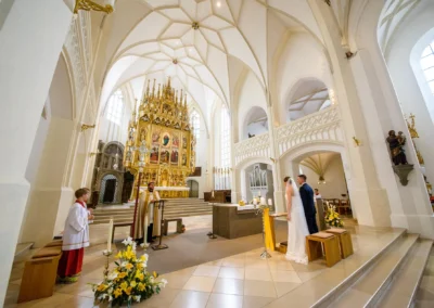 Kirchliche Trauung in der Stadtpfarrkirche Maria Himmelfahrt, Hochzeitsfotografie, Brautpaar vor Altar.