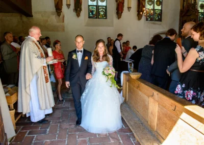 Brautpaar bei kirchlicher Trauung in Obermenzing, Hochzeit in Kirche, festliches Ereignis dokumentiert von Hochzeitsfotograf.