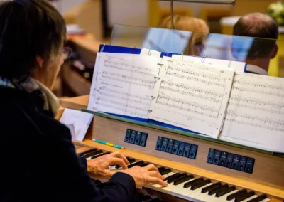 Organist spielt waehrend der kirchlichen Trauung einer Hochzeit in einer Kirche in Bernried. Hochzeitsfotograf-Aufnahme.