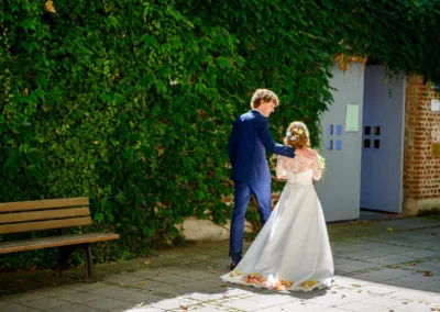 Brautpaar bei Hochzeit in Sendling vor begruenter Wand, Hochzeitsfotograf aus München, romantische Trauung.