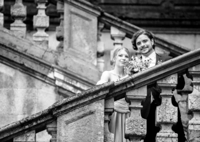 Brautpaar auf Treppe bei Hochzeitsportraits in München-Bogenhausen, Hochzeitsfoto im eleganten Schwarz-Weiss-Stil.