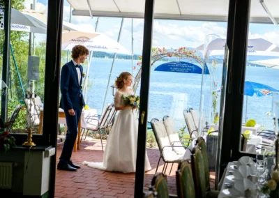 Brautpaar an Hochzeitstafel mit Seeblick am Chiemsee, festlich bei sonniger Trauung im Malerwinkel, Hochzeitsreportage.