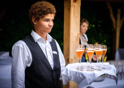 Kellner serviert Champagner bei Hochzeitsfeier im Terrassenhof, Bad Wiessee. Stimmungsvolle Momentaufnahme.