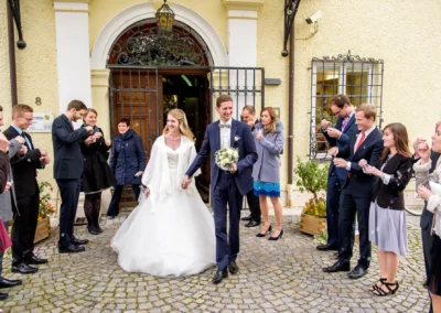 Brautpaar bei ihrer Hochzeit in Bernried, umgeben von Gaesten, die Seifenblasen pusten. Hochzeitsreportage.
