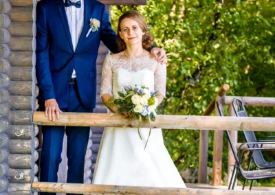 Brautpaarfoto an einer Holzhutte bei einer Hochzeit am Chiemsee, Hochzeitsfotograf. Sommerliche Hochzeitsreportage.