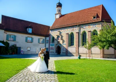 Brautpaar vor Schloss Blutenburg. Hochzeitsfotografie in Muenchen Obermenzing in idyllischem Ambiente nach der Trauung.