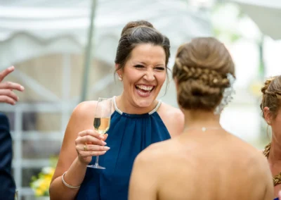 Gäste lachen und feiern mit Sektgläsern bei einer Hochzeitsfeier in ViCulinaris, eingefangen von einem Hochzeitsfotografen.