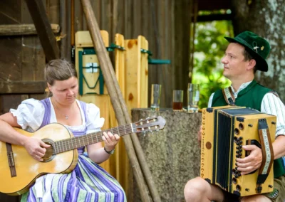 Musiker spielen Gitarre und Akkordeon bei der Hochzeitsfeier im Hotel Kolbergarten. Hochzeitsfoto in Bayern.