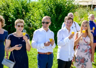 Gaste bei der Hochzeitsfeier in Oberbayern, geniessen Drinks im Freien. Hochzeitsreportage Chiemsee.