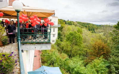 Hochzeitsfeier in Pullach mit roten Ballons auf Terrasse, im Hintergrund das Isartal, festgehalten in Hochzeitsreportage.